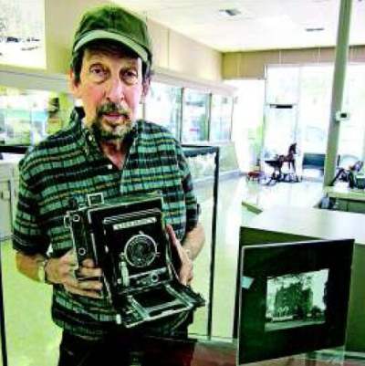 Charles King holds Camera of Charles Brady - photographer